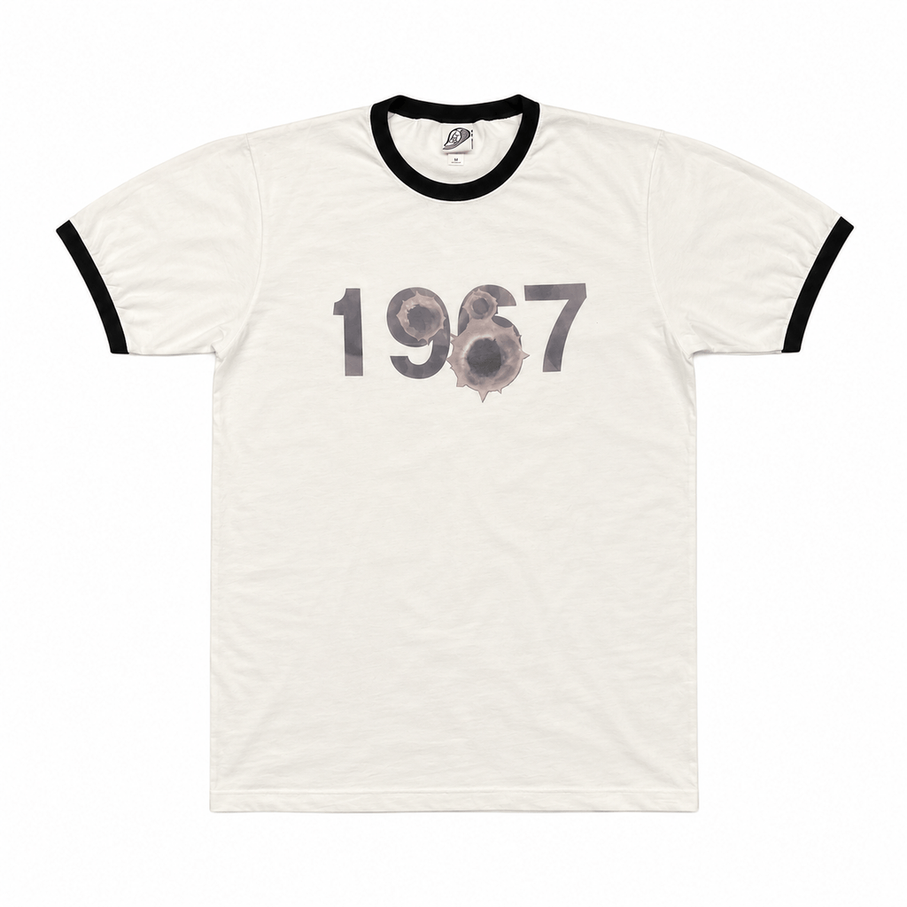 White 1967 ringer tee with distressed black logo and bullet hole detail