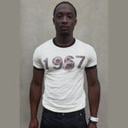 White 1967 TEE ringer tee with distressed bullet hole graphic on model