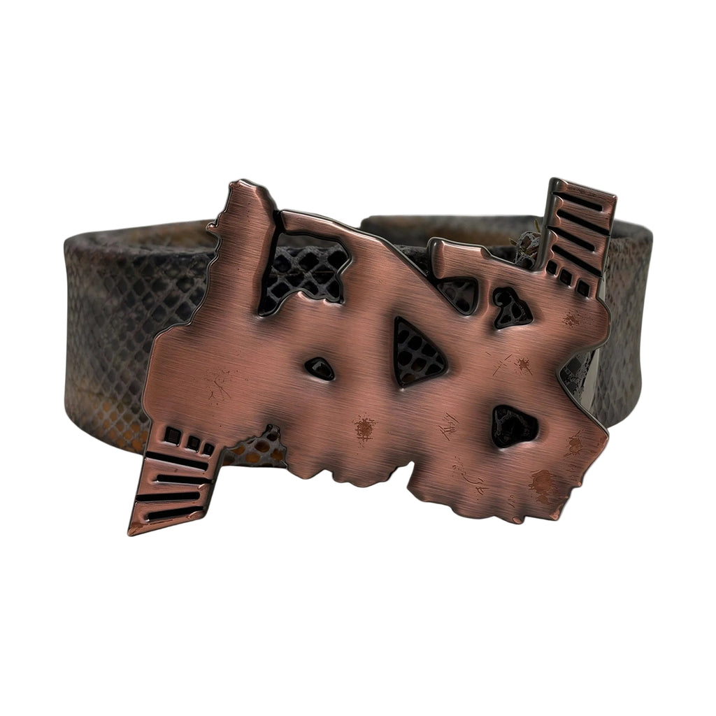 Close-up of sculpted copper buckle on textured leather strap